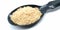 A picture of asafoetida powder on black spoon,
