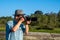 A picture of an Asian man aiming his camera and taking pictures outdoor.