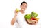 A picture of an Asian man eating an apple and carrying healthy fruits and vegetables