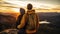 the picture of the back view of a couple of hikers on a mountain peak during golden hour