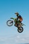 A picture of a biker making a stunt and jumps in the air