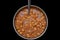 Picture of chole chana masala sabji in round vessel with spoon and black background