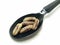 A picture of date seed isolated on a black spoon  ,