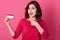 Picture of emotional good looking pretty female pointing with forefinger at credit card, having surprised facial expression,