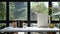 Picture frame, coffee cup, books and plower pot on white table near glass window.