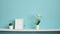 Picture frame mockup. White shelf against pastel turquoise wall with potted orchid and hand putting do