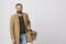 Picture of handsome man smiling to the camera wearing casual clothes and a bag over white background. Businessman walks