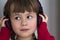 Picture of happy pretty child little girl with big headphones at home. Joyful child girl listening to music on gray blurred backgr