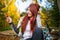 Picture of happy woman with cellular phone in autumn forest