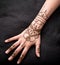 Picture of human hand being decorated with henna