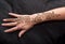 Picture of human hand being decorated with henna