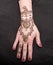 Picture of human hand being decorated with henna