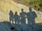 Picture with human shadows on a rock wall, seashore