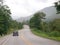 Picture of a lonely rural narrow road in tropical lands with green trees and hill