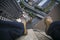 Picture of male leg setting on the edge of building site wearing blue pant, steel cape working safety boot with blurring construct