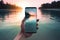 Picture of mans hand holding smartphone with beautiful picture on screen. Tropical beach with palms white sand and turquose water