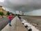 A picture of Marine Drive where a man wearing mask taking photos of the seaside in the rainy day during the lockdown in Mumbai.