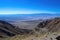 picture of mountain range, with winding road and clear blue sky in the background