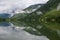 A picture of the mountains and passing freight train being symmetrically reflected on the surface of a lake.