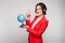 Picture of pretty woman in red blazer with earth sphere in hands