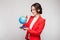 Picture of pretty woman in red blazer with earth sphere in hands