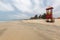 Picture of a red watchtower with a yellow ladder at the beach surrounded by the sea in the Gambia