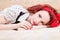 Picture of sensual red haired young woman beautiful pinup girl having fun relaxing lying in bed smiling & looking at camera