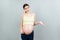 Picture of shocked or surprised pregnant lady standing over colored background. Looking at camera