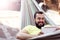 Picture showing happy man resting on hammock with tablet