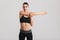 Picture of slim beatiful woman doing aerobic exercise and stretching her body, isolated over gray background