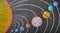 Picture of solar system drawn on black paper using crayon colors.