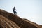 Picture of sportsman with backpack and walking sticks on hill