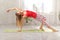 Picture of sporty beautiful blond young woman in sportswear working out in hall, doing Variation of Bridge Pose.