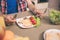 A picture of tasty omlet with letuce and cherry tomatoes on plate on table. Guy holds knife and fork in hands. He is
