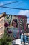 A picture of two big murals covering two sides of building.  Title:The Present is a Gift. Artist:Drew Young, Jay Senetchko      Au