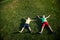 Picture of two brother having fun in the park  two cheerful children laying down on green grass  little boy and his friend playing