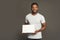 Picture of young african-american man holding white blank board