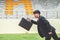 Picture of young businessman holding a briefcase and sprinting on the lanes of a track, Competition concept