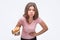 Picture of young woman burp. She hold one hand on stomach and another one with burger. Model feel sick. Isolated on