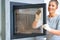 Picture of young woman cleaning fireplace glass doors