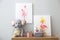 Pictures and stationery with toys on wooden table in children`s room. Interior design