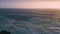 Picturesque aerial ocean sunrise with dark ripple water surface. Foamy waves