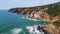 Picturesque aerial rugged seashore washing by powerful ocean in slow motion.