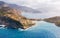 Picturesque aerial shot of colorful fishing Asos village houses on Cephalonia island, Greece. Steep cliff banks washed by blue