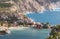 Picturesque aerial shot of colorful fishing Asos village houses on Cephalonia island, Greece. Steep cliff banks washed by blue