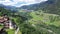 Picturesque aerial view of houses of small Swiss village Cavardiras in mountain valley in sunny summer day