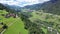 Picturesque aerial view of houses of small Swiss village Cavardiras in mountain valley in sunny summer day