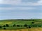 Picturesque agricultural landscape. Green hills, blue sky. Hilly terrain in the south of Ireland, nature