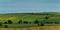 Picturesque agricultural landscape. Green hills under a blue sky. Hilly terrain in the south of Ireland, nature