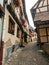 Picturesque alleys of Eguisheim, tipical old houses decorated with flowers., France